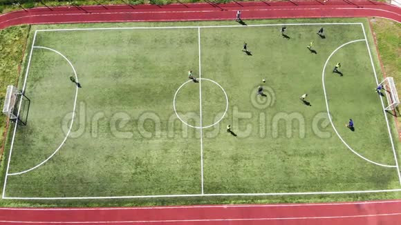 顶部的空中景观孩子们通过在一个小足球场上踢足球来进球视频的预览图
