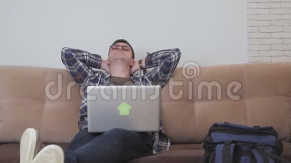 一位中年男子坐在沙发上手提电脑在脊柱上疼痛他的头在旋转视频的预览图
