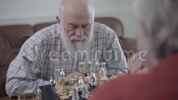 两个老人下棋坐在家里的皮沙发上大胡子的人在动高加索老人视频的预览图