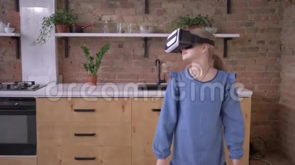 现代童年戴着虚拟现实眼镜的小女孩在家玩视频的预览图