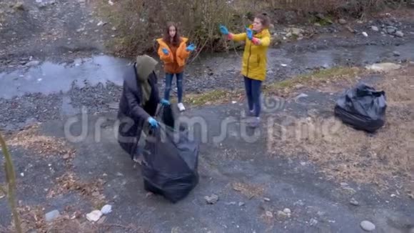 环境问题志愿者在河岸上收集垃圾视频的预览图