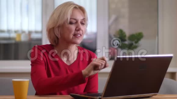 在一个舒适的房间里一个年轻的白种人女人在笔记本电脑上打了一个视频电话在室内愉快地交谈视频的预览图