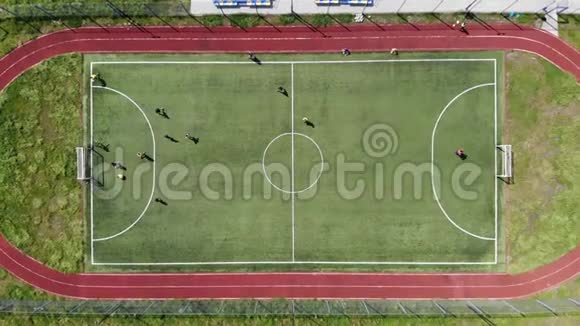 顶部的空中景观孩子们通过在一个小足球场上踢足球来进球视频的预览图