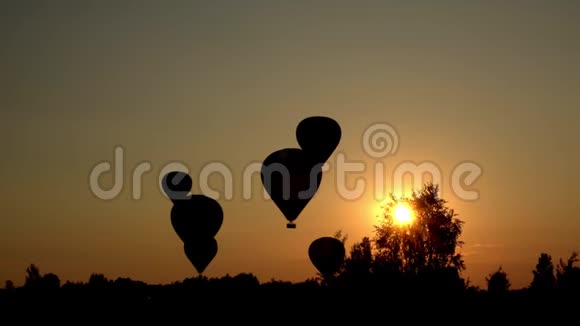 热气球的轮廓降落在令人惊叹的日落阳光穿透视频的预览图