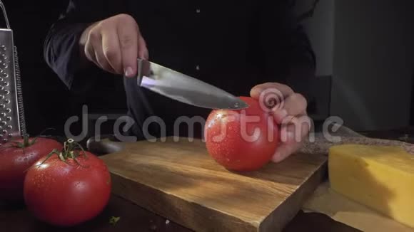 厨师用锋利的刀把熟透的红西红柿切成一圈圈在木板上蔬菜沙拉的配料烹饪视频的预览图