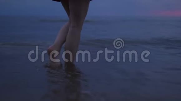 女人赤裸的双腿贴近行走的水令人惊叹的黑暗风景生动的深红色日落与紫罗兰和洋红色视频的预览图