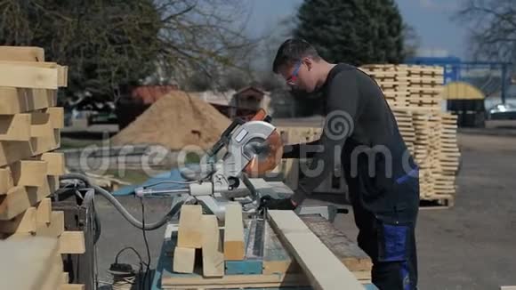 工业青年木工穿着特殊制服使用木材切割机视频的预览图