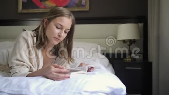 女人正在看书躺在家里的床上视频的预览图