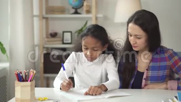 快乐的小学生在写作和学习成功后拥抱她的老师视频的预览图