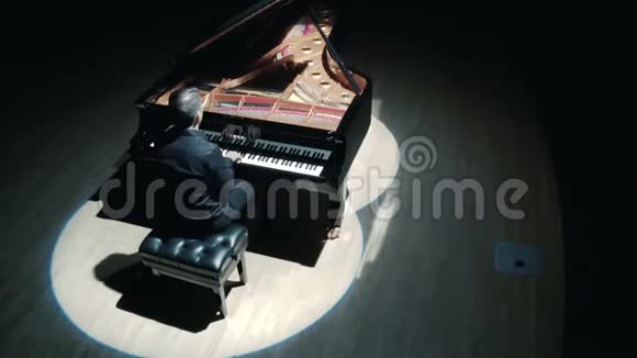 舞台上的大钢琴一个穿着黑色西装的优雅男子在音乐厅的舞台上演奏大钢琴视频的预览图