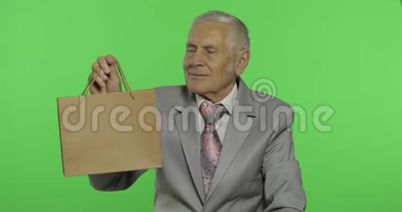 带购物袋的老人看着镜头伸展礼物视频的预览图