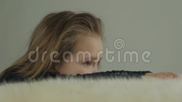 悲伤的小女孩堆在桌子上上面有一块白色的羊皮视频的预览图