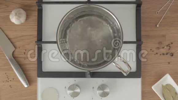 人将意大利面放入锅中的沸水中用勺子搅拌视频的预览图