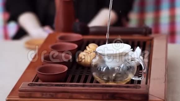 通过水壶里的筛子倒入美味的茶然后倒入杯子里茶道仪式视频的预览图