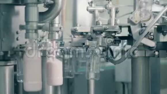食品厂的自动化生产线在工厂用酸奶填充瓶子的过程视频的预览图