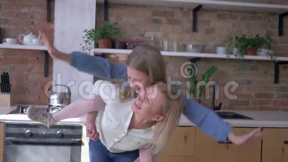 和妈妈玩得开心快乐的小女孩和妈妈坐在后面玩把飞机伸到厨房里视频的预览图