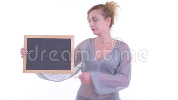 一个穿着衣服的金发女人拿着黑板竖起大拇指视频的预览图