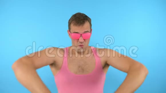 穿着粉色眼镜在蓝色背景上跳舞的时髦男人视频的预览图