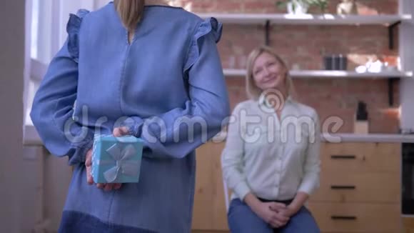 母亲节快乐可爱的小女儿祝贺可爱的妈妈送礼物盒温柔地拥抱视频的预览图
