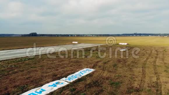 田野里的旧跑道上有一架小型喷气式飞机降落视频的预览图