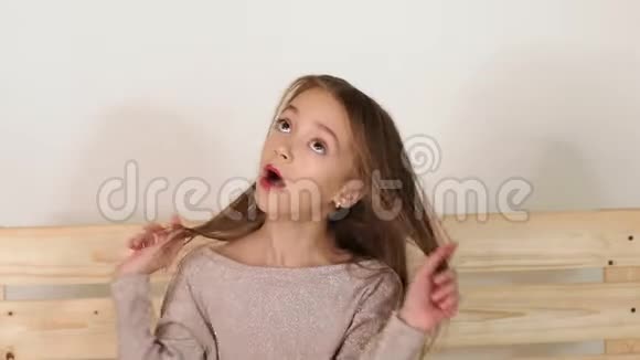 一个穿着闪亮夹克的小女孩坐在工作室的木制自制长凳上视频的预览图