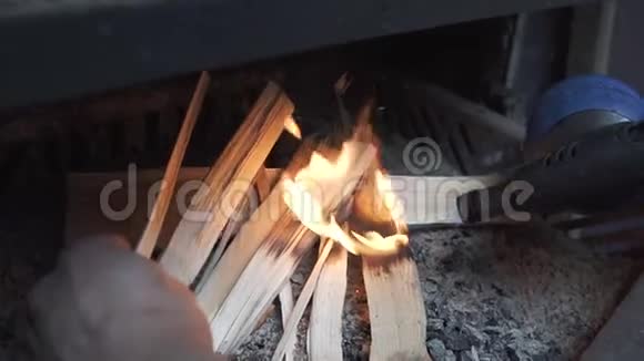 点燃火种点燃柴火在烤架上点燃火焰在阳光明媚的夏日烧烤在明火上烹饪准备视频的预览图