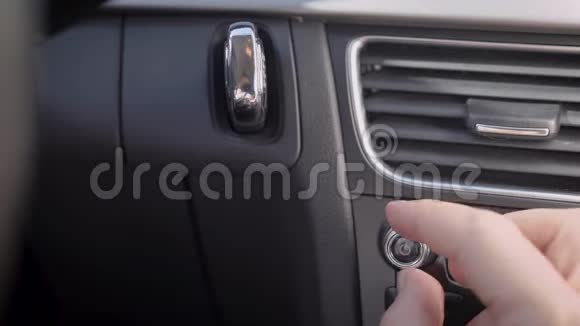 在框架中一个人的手和一个汽车音频音量旋钮司机或乘客调整音乐音量水平视频的预览图
