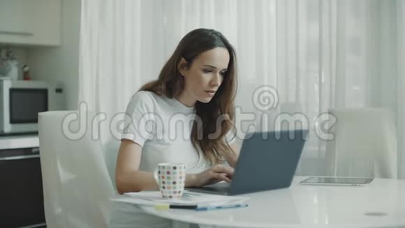 厨房里用笔记本电脑的女人女商人看新闻的画像视频的预览图