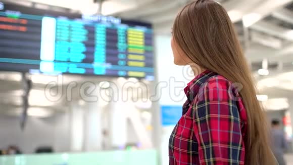旅行妇女在机场使用智能手机年轻的白种人旅行者用手机应用程序检查登机时间视频的预览图