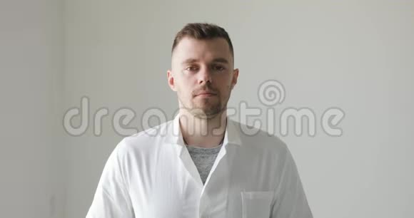 穿着白色外套的男医生在白色背景上微笑视频的预览图