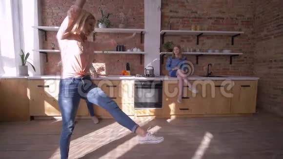 快乐灵活的女孩在家里的厨房里当着妈妈和姐姐的面做体操空翻视频的预览图