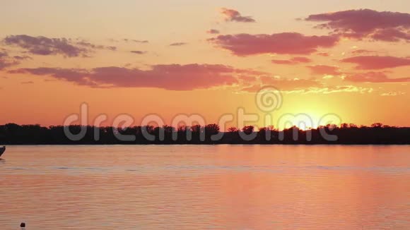 美丽的湖泊景观海岸线漂浮的渡船在可爱的橙色日落视频的预览图