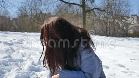 漂亮的女人戴着蓝色的镜子太阳镜直发黑发在公园的户外玩雪球视频的预览图