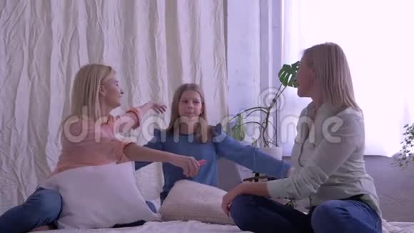 幸福的家庭妈妈和女儿拥抱在一起在家里的床上交流视频的预览图