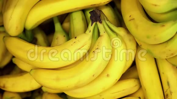 许多黄色香蕉特写旋转在一个4K背景在商店为买家视频的预览图