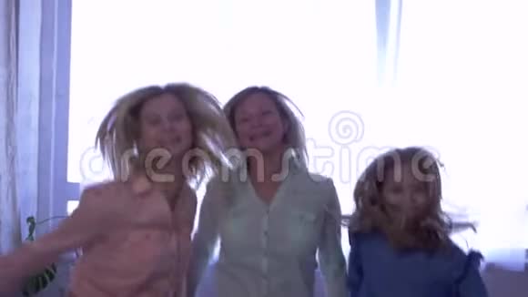 父母的爱妈妈和女儿跳上床然后拥抱在一起视频的预览图
