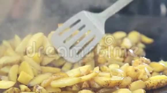 煮炒土豆土豆在柴火上炸上面覆盖着烟视频的预览图