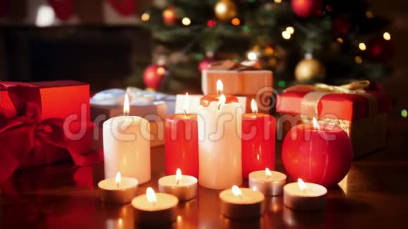 4k特写视频在木桌上放蜡烛和圣诞礼物放在圣诞树上视频的预览图