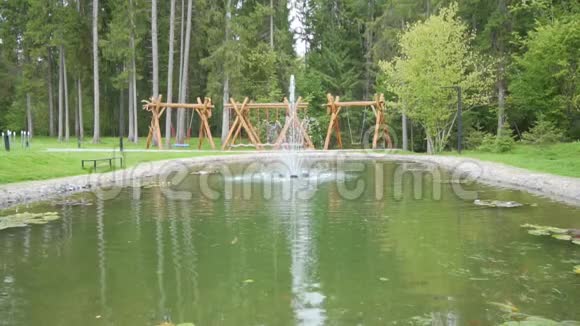 绿色池塘中的喷泉和锦鲤鱼视频的预览图