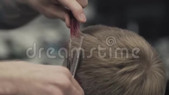 理发师用剪刀剪头发理发店里男人的发型视频的预览图