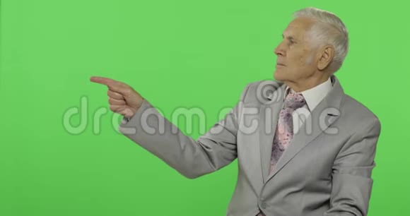 年长的商人指着什么竖起大拇指穿着正式服装的老人视频的预览图