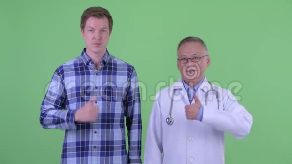 快乐成熟的日本男医生和年轻人一起竖起大拇指视频的预览图