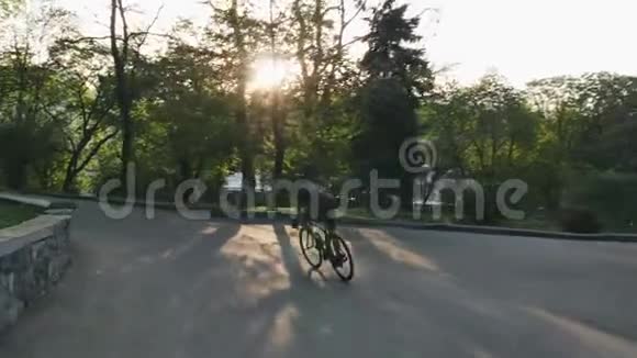 骑自行车的人骑在公园路上骑着自行车下山的瘦小的骑车人慢动作视频的预览图