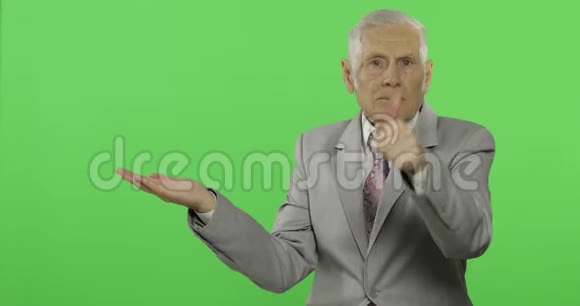 年长的商人指着什么竖起大拇指穿着正式服装的老人视频的预览图
