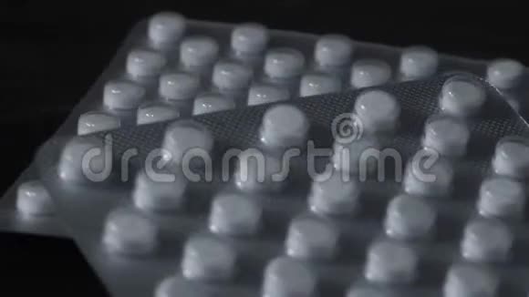 药丸在黑色背景特写上旋转视频的预览图