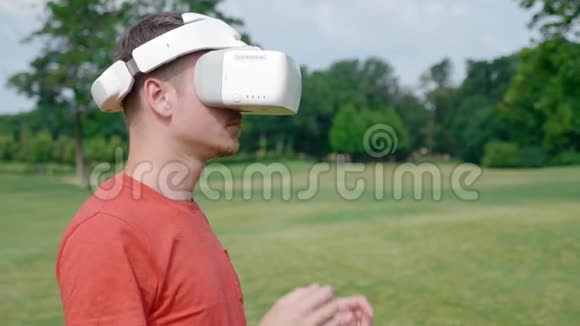 一个人从公园的头上摘下他的VR耳机视频的预览图