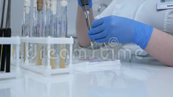 一位年轻的女化学家正在做一项化学物质的科学实验研究人员将化学品滴入试验管中视频的预览图
