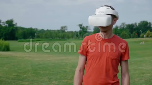 一个男人在公园里用VR耳机躲避障碍物视频的预览图