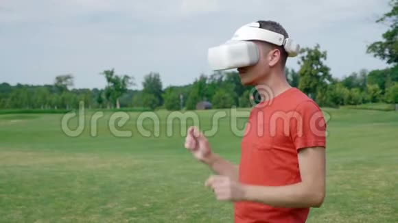 一个人从公园的头上摘下他的VR耳机视频的预览图