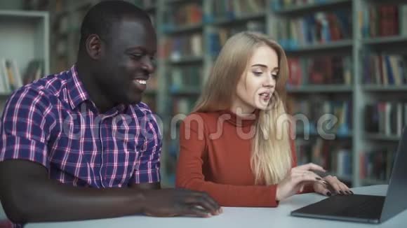 欧洲的女士和非裔美国人都在微笑着看着笔记本电脑视频的预览图